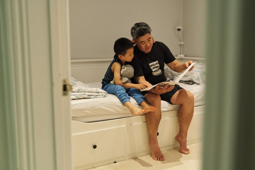 Child and father reading in the room together during a neurodivergent friendly family photo session in London