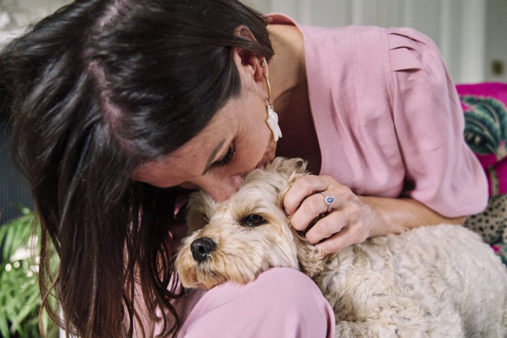 Woman kissing her prop which is a dog during a professional portrait session.
