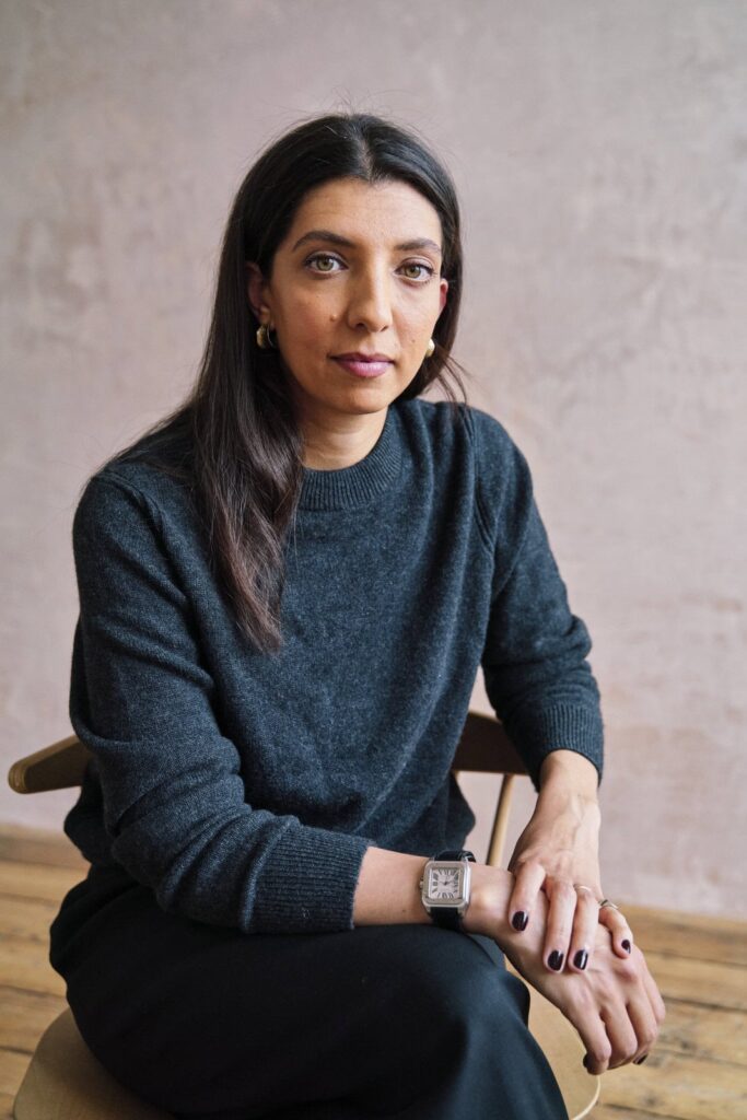 Woman wearing a black outfit with simple accessories with great make-up and nail polish at her professional portrait photo session. 