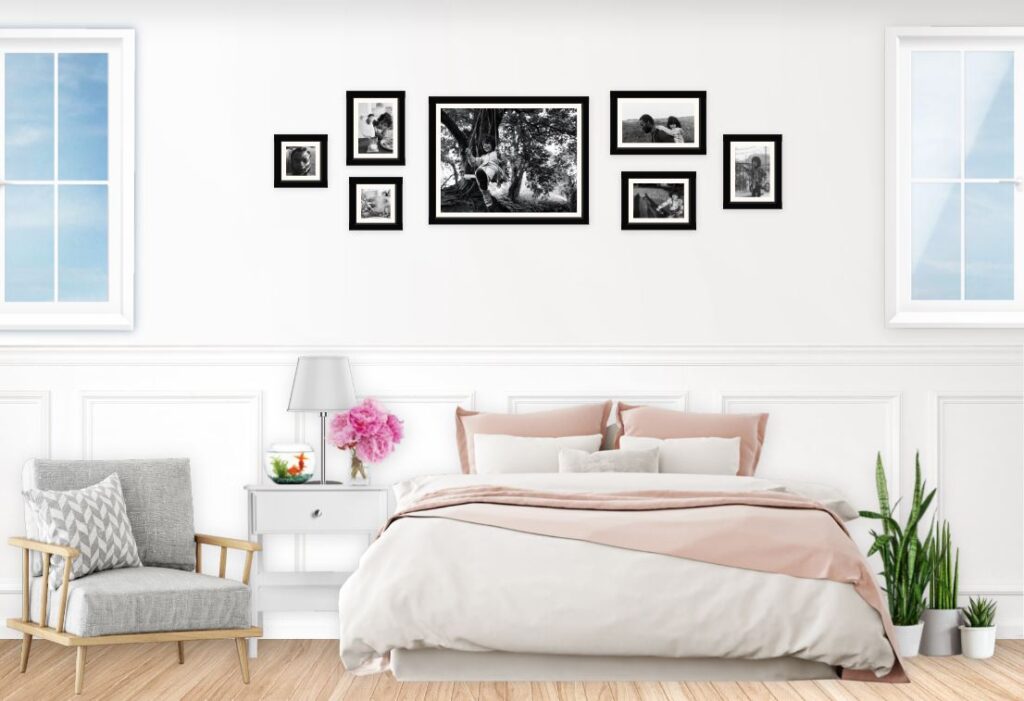 Gallery wall with black and white family photos above the bed in the bedroom.