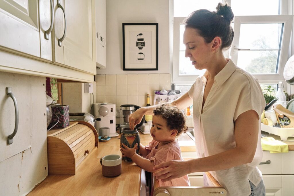 Your family is not too busy for family photos as I take pictures of your everyday like this mom helping her toddler in the kitchen. 