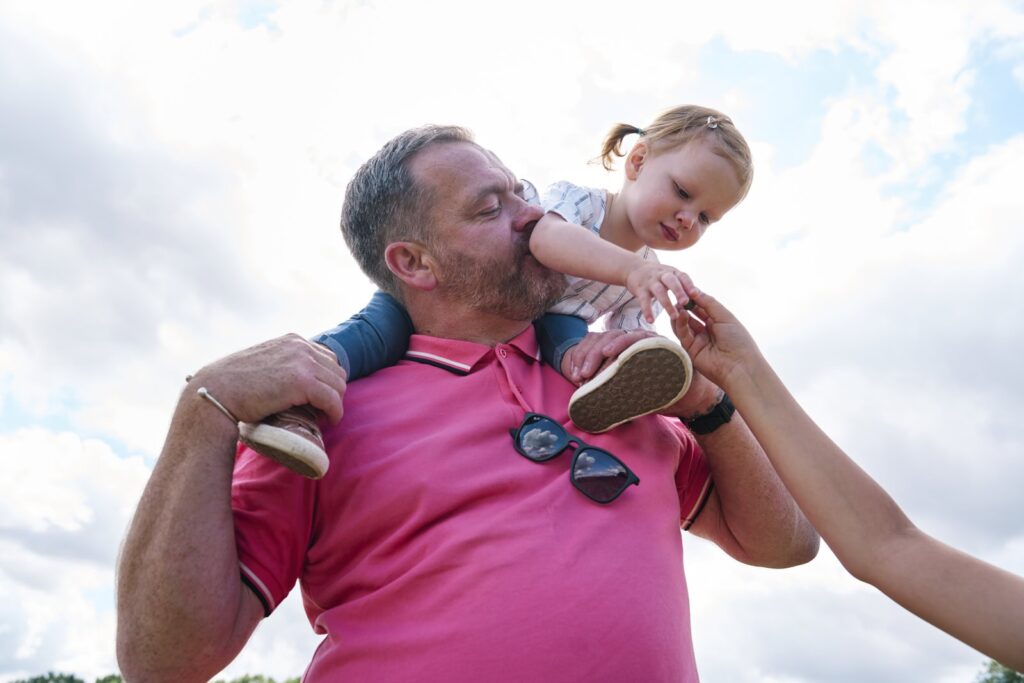 Child high up on dads shoulders during a family photo session in London