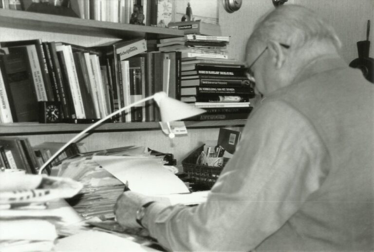 Grandfather sitting at his desk writing captured by his teen granddaughter photographer Saskia Albers.